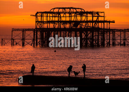 Brighton, East Sussex. Dezember 2017 19. UK Wetter. Bright Red Skies bei Sonnenuntergang am Ende des Tages, wo eine Herde von Tausende von Staren, die auf eine murmuration Anzeige oberhalb von Brighton West Pier. Credit: Francesca Moore/Alamy leben Nachrichten Stockfoto