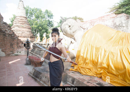 Hübsche Asiatin in der Thailändischen alten Krieger am Wat Phutthaisawan Tempel in Ayutthaya Historical Park, Thailand posieren. Stockfoto