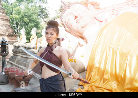 Hübsche Asiatin in der Thailändischen alten Krieger am Wat Phutthaisawan Tempel in Ayutthaya Historical Park, Thailand posieren. Stockfoto