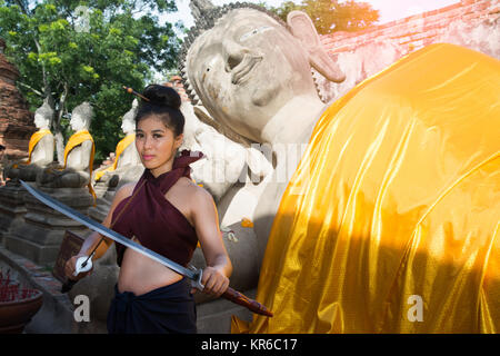 Hübsche Asiatin in der Thailändischen alten Krieger am Wat Phutthaisawan Tempel in Ayutthaya Historical Park, Thailand posieren. Stockfoto