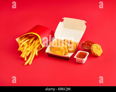 Chicken Nuggets und Pommes frites auf rotem Hintergrund Stockfoto