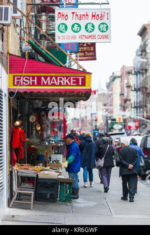 Von außen ein fischhändler mit Fisch auf dem Display und Eigentümer außerhalb als Menschen gehen vorbei, Chinatown, New York, USA Stockfoto