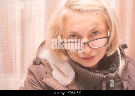 Frau mittleren Alters Tragen einer Brille und Jacke in einer guten Stimmung, gefilterten Bild Stockfoto