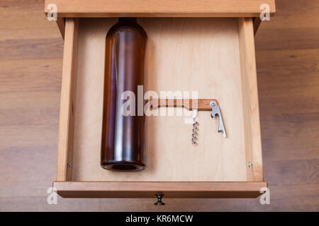 Leere Flasche Wein und Korkenzieher in offenen Schublade Stockfoto