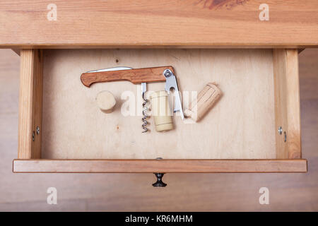 Faltbarer Korkenzieher und Korken in offenen Schublade Stockfoto