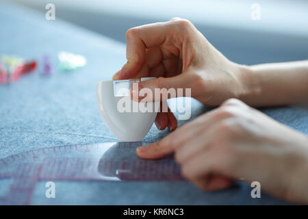 Nahaufnahme von geschickten Händen individuelle Kennzeichnung und Messung der Stoff während der Kleidung. Stockfoto