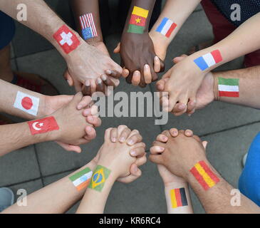 Internationale Brüder und Schwestern stehen im Kreis zusammen und halten die Hände Stockfoto