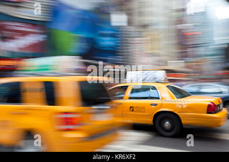 Yellow Cabs Fahren auf der Straße in der Nähe des Times Square in Manhattan, New York, USA, Bewegungsunschärfe. Stockfoto