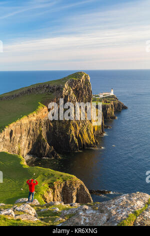 Hohen winkel Blick Richtung Leuchtturm an der Spitze der Klippe Point mit Blick über den Ozean, Rückansicht der Mann in Rot oben bewundern. Stockfoto