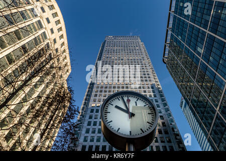 Die riesige Uhr an der Canary Wharf dominiert den Vordergrund vor dem Canada Square No 1, Canary Wharf, London Stockfoto