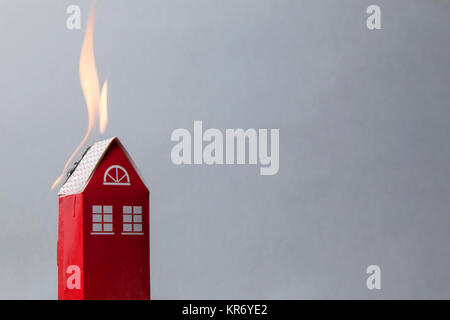 Haus Feuer Konzept. Spielzeug Haus mit Flammen Stockfoto