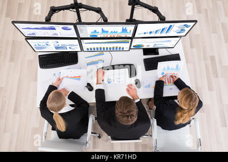 Junge Geschäftsleute Arbeiten mit Diagrammen auf mehreren Computern Stockfoto