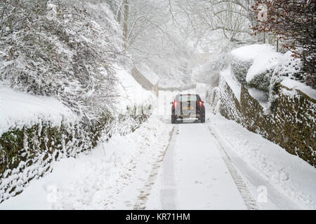 Der Dacia Duster Fahrt auf einer verschneiten Landstraße in der Nähe von Snowshill Dorf im Dezember. Snowshill, Cotswolds, Gloucestershire, England Stockfoto