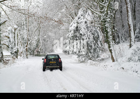 Der Dacia Duster Fahrt auf einer verschneiten Landstraße in der Nähe von Snowshill Dorf im Dezember. Snowshill, Cotswolds, Gloucestershire, England Stockfoto