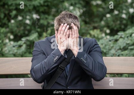 Traurig Geschäftsmann sitzt auf der Bank Stockfoto