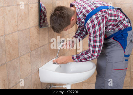 Klempner zur Festsetzung Tippen mit Waschbecken Stockfoto