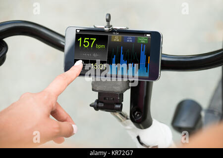 Finger, der bei Smart Phone mit Heartbeat Rate Stockfoto