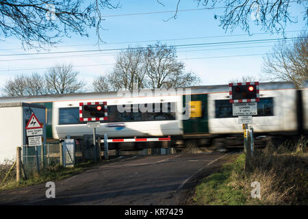 Personenzug über Bahnübergang Stockfoto