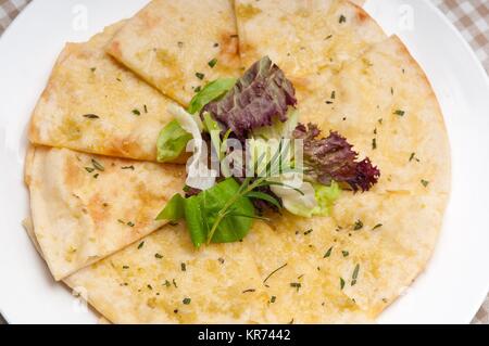 Knoblauch-Pita-Brot-Pizza mit Salat an der Spitze Stockfoto