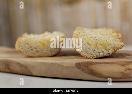 Zwei Scheiben geröstetes Baguette mit zerlassener Butter und Pfeffer Stockfoto