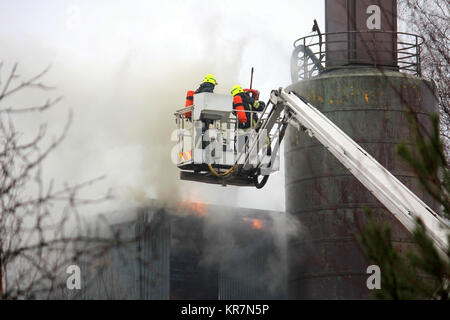 SALO, Finnland - 16. FEBRUAR 2014: Feuerwehrmänner löschen Feuer auf einem hydraulischen Kran Plattform an der Salo Zementwerk. Stockfoto