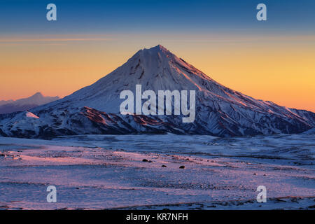 Atemberaubende Winter Berge Landschaft der Halbinsel Kamtschatka - Morgen schneebedeckten Kegel des Vulkans bei Sonnenaufgang Stockfoto