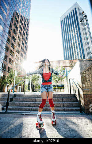 Asiatische Frau rollerskating in Stadt Stockfoto