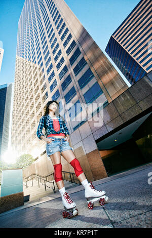 Asiatische Frau rollerskating in Stadt Stockfoto