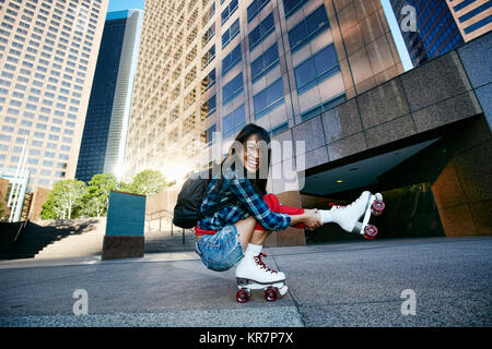Asiatische Frau rollerskating in der Stadt auf ein Bein Stockfoto