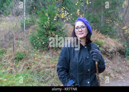 Dame mit Brille blue Beret stehen im Wald Stockfoto