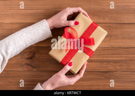 Junge Frau Hände, die Geschenkverpackung. Stockfoto