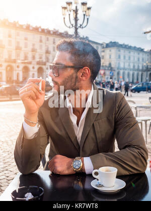 Trendy Mann im Cafe draußen Kaffee trinken Stockfoto