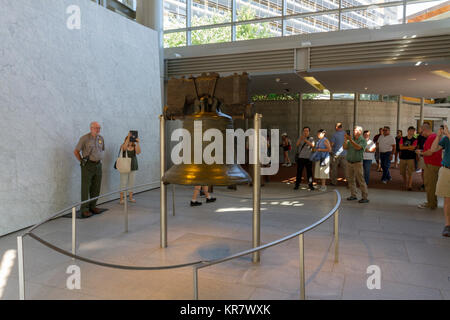 Besucher sehen die Liberty Bell auf die Liberty Bell, Independence Hall, Philadelphia, Pennsylvania, USA. Stockfoto