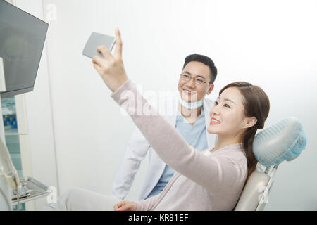 Männliche Zahnärzte und weibliche Patienten mit Handys Fotos machen Stockfoto
