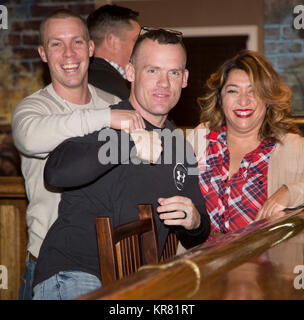 (Von links nach rechts) Staff Sgt. Justin Mears, Exchange Store Manager, Gunnery Sgt. Justin Kratzer, S-6 Communications, und Veronica Reveles, MCCS, genießen Sie einen humoristischen Moment während des MCLB Barstow Urlaub Partei, Maj Gen James L. Tag Conference Center, Dez. 6 statt. Stockfoto