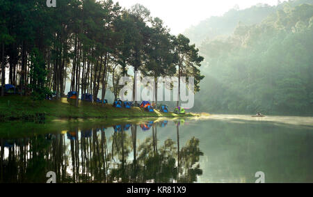 Schöne Landschaft, camping Zelte auf einen Campingplatz in der Nähe des Sees mit Sonnenlicht und Nebel auf dem Wasser Stockfoto