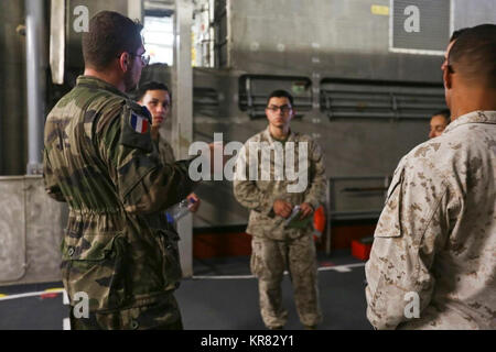 5. US-Flotte von Operationen (31. 9, 2017) - Französische Sailor Petty Officer John Schoeser (ganz links), erklärt, Ship-to-shore Verfahren zu Naval Amphibious Force, Task Force 51, 5. Marine Expeditionary Brigade (TF 51/5) Marines an Bord der Französischen Amphibious Assault ship LHD Tonnerre (L 9014) bereitgestellt werden. Tonnerre, mit Eingeschifft Marinesoldaten und Matrosen aus dem 15 Marine Expeditionary Unit und TF 51/5, ist die Durchführung Maritime Security Operations innerhalb der USA 5 Flotte Einsatzgebiet die regionale Stabilität, die die Freiheit der Schiffahrt und des freien Handels zu gewährleisten. (U.S. Marine Corps Stockfoto