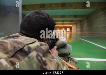 Us-Armee SPC. Manuel Northy, mit dem chièvres Provost Marshall Büro in der US-Armee Garnison Benelux, schießt mit einem M4-Karabiner, um in der 25-m-Bereich, in Chièvres, Belgien, Dez. 12, 2017 zu qualifizieren. Die Qualifikation war Teil der Strafverfolgung Zertifizierung. (U.S. Armee Stockfoto