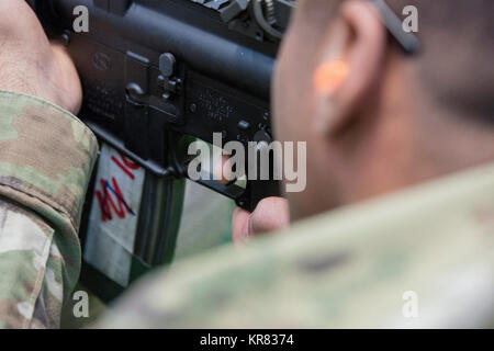 Der Zeigefinger der US-Armee SPC. Manuel Northy, mit dem chièvres Provost Marshall Büro in der US-Armee Garnison Benelux, ist auf den Auslöser, als Er schießt mit einem M4-Karabiner, um in der 25-m-Bereich, in Chièvres, Belgien, Dez. 12, 2017 zu qualifizieren. Die Qualifikation war Teil der Strafverfolgung Zertifizierung. (U.S. Armee Stockfoto