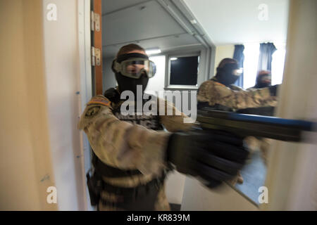 Us-Armee SPC. Scarlett Mitchell, mit chièvres Provost Marshall Büro in der US-Armee Garnison Benelux, löscht einen Flur ihr Team an einer simulierten Active shooter Situation in Caserne Daumerie, Chièvres, Belgien, Dez. 12, 2017 reagiert. Die Soldaten für ihre Strafverfolgungsbehörden Bewertung ausgebildet. (U.S. Armee Stockfoto