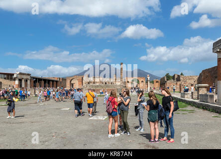 Touristen in die Ruinen des Forum Romanum in Pompeji (Pompei) mit Blick auf den Vesuv im Hintergrund, Neapel, Kampanien, Italien Stockfoto