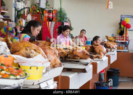 Frauen verkaufen Schwein braten zu Mittag, Cuenca indoor Food Market, Cuenca, Ecuador Lateinamerika Stockfoto