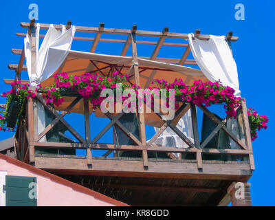 Burano, Italien, 10. Mai 2014: Der ursprüngliche hölzerne Veranda mit Tisch und Stühlen Stockfoto