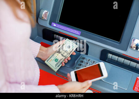 Rückzahlung auf Kredit. Frau Hand Geldabheben von Outdoor-Bank ATM Stockfoto