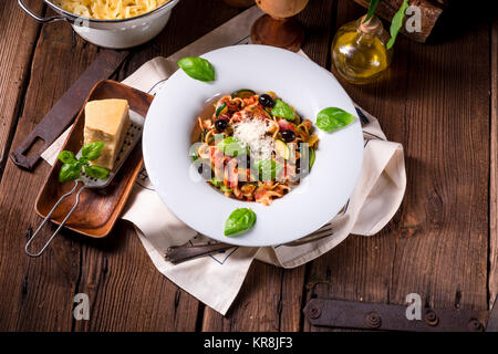 Ribbon Pasta mit Zucchini und Oliven in Tomatensoße Stockfoto