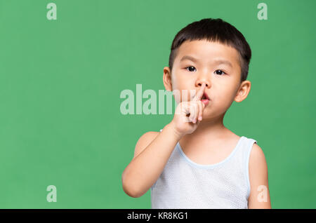 Little Boy ein hush Geste Stockfoto