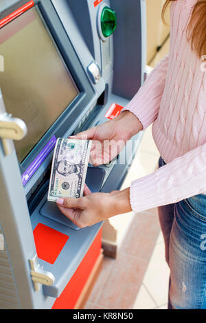 Rückzahlung auf Kredit. Frau Hand Geldabheben von Outdoor-Bank ATM Stockfoto