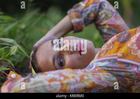 Portrait einer jungen Frau, die Verlegung auf dem Rasen, Nahaufnahme Stockfoto