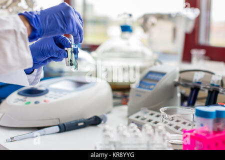 Junge Wissenschaftlerin arbeitet in der modernen Chemie/Biologie Labor (flacher DOF Farbe getonte Bild) Stockfoto