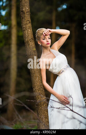 Schöne Braut an ihrem Hochzeitstag im Freien in einem Wald (Farbe getonte Bild flach DOF) Stockfoto